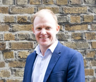 Picture of Nick Henderson, CEO of the Irish Refugee Council in front of a brickwall