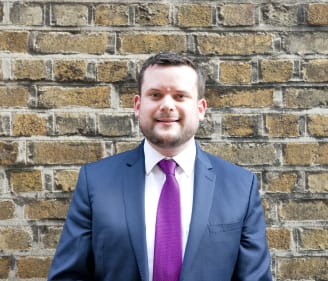 Headshot of Brian Collins, Irish Refugee Council Law Centre Senior Solicitor in front of a brick wall