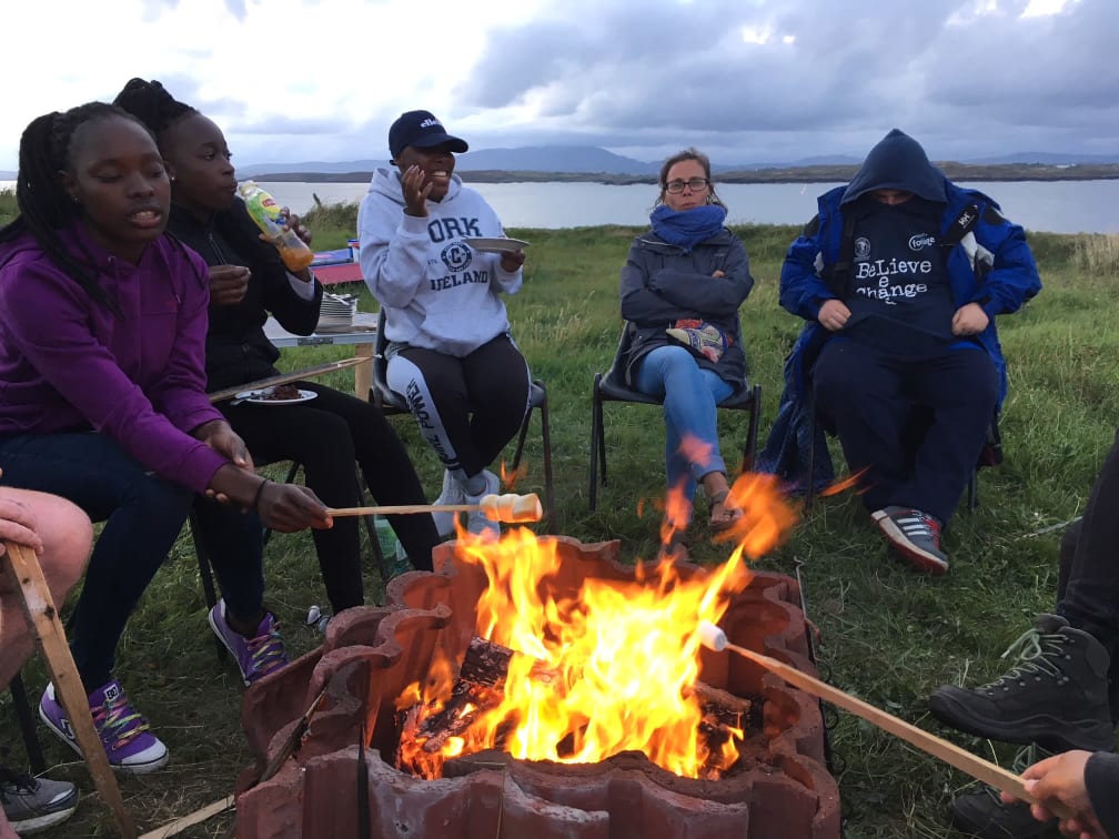 Young people sitting around a fire at the Irish Refugee Council residential retreat Our Voice